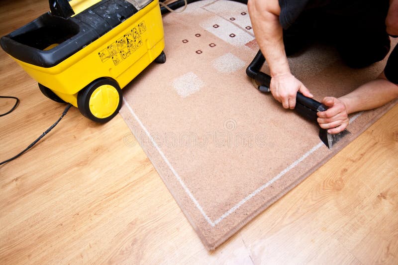 Fachowy dywanika cleaner przy pracą zdjęcia stock Fachowy dywanika cleaner przy pracą zdjęcia stock
