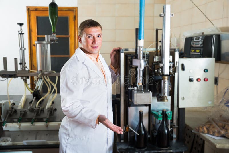 Fachowy konwejeru pracownik sprawdza ilość w wytwórnii win obraz stock Fachowy konwejeru pracownik sprawdza ilość w wytwórnii win obraz stock