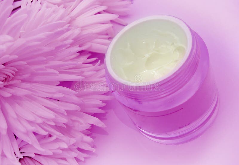 Facial cream and flowers in pink