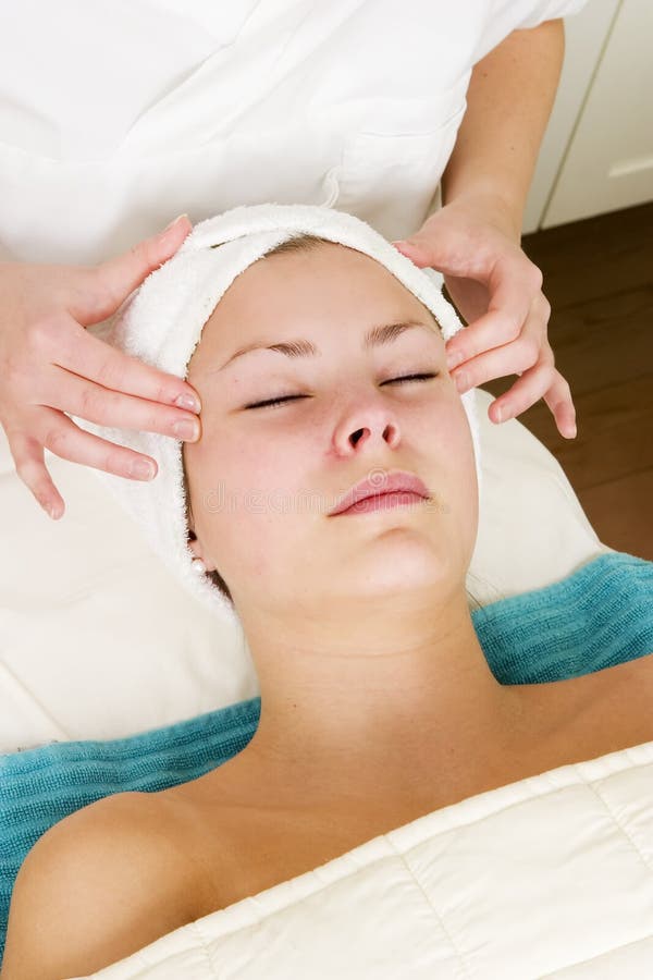 A woman receiving a facial massage at a beauty spa.