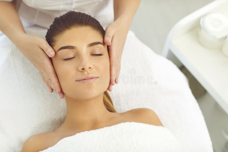 Facial Massage Hands Of Cosmetologist Massaging Relaxed Womans Face In Spa Beauty Salon Stock