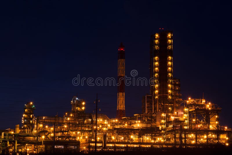 Factory with bright lights at sunset, gas and oil production