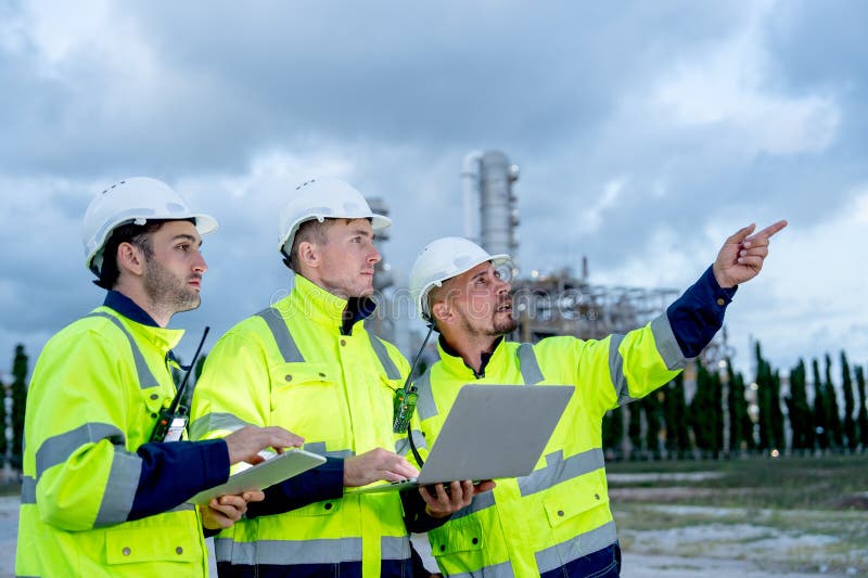 Factory engineer or technician workers with one hold laptop and other hold tablet also one point to right side stand in front of stock image