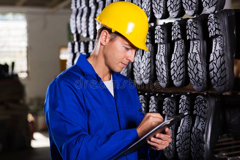 Gumboot factory worker checking inventory in stockroom. Gumboot factory worker checking inventory in stockroom