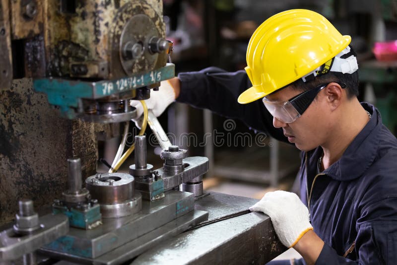 Factory worker using wrench to fix the machine