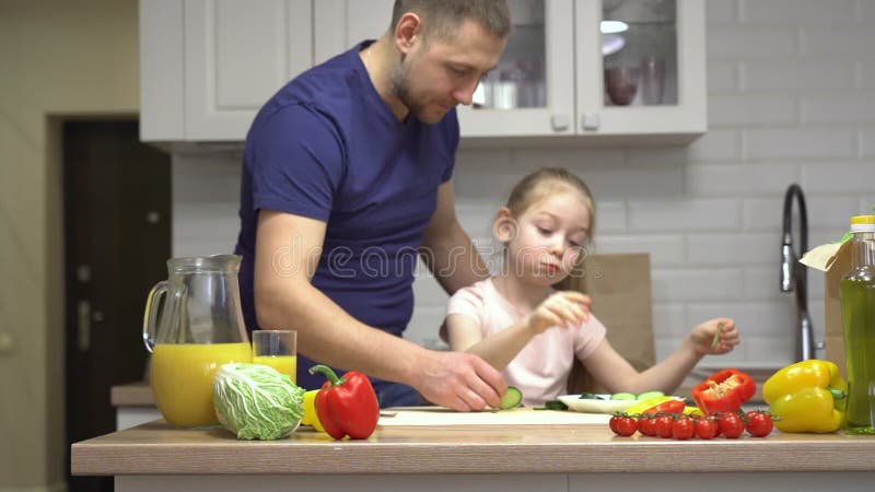 Fader lär sin dotter hälsosam mat i familjeköket stock video