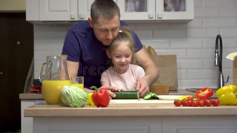Fader och dotter leende när de lagar frisk mat tillsammans lager videofilmer