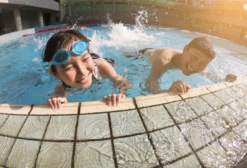 Fader och dotter som spelar i simbassäng arkivbilder Fader och dotter som spelar i simbassäng arkivbilder
