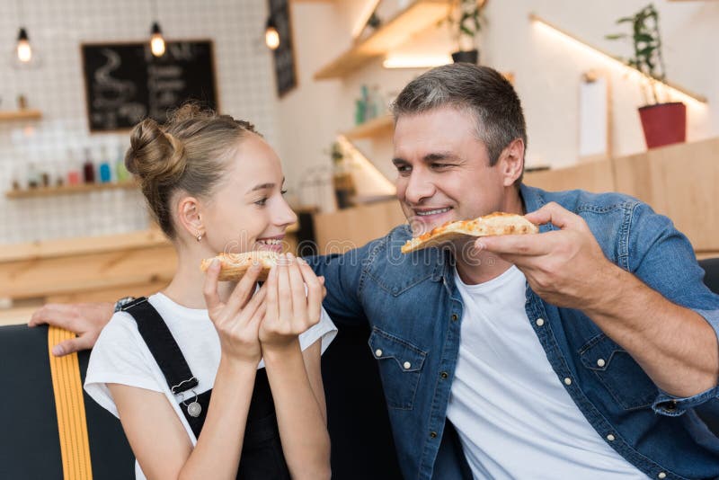 Fader och dotter som äter pizza royaltyfri fotografi Fader och dotter som äter pizza royaltyfri fotografi