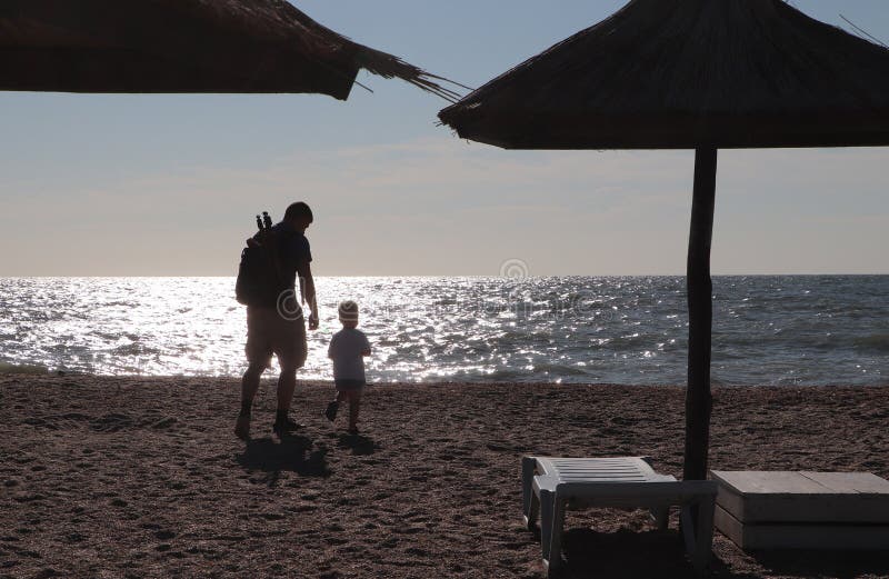 Fader och pojke som spelar på stranden på solnedgångtiden, begrepp av den vänliga familjen royaltyfri foto Fader och pojke som spelar på stranden på solnedgångtiden, begrepp av den vänliga familjen royaltyfri foto