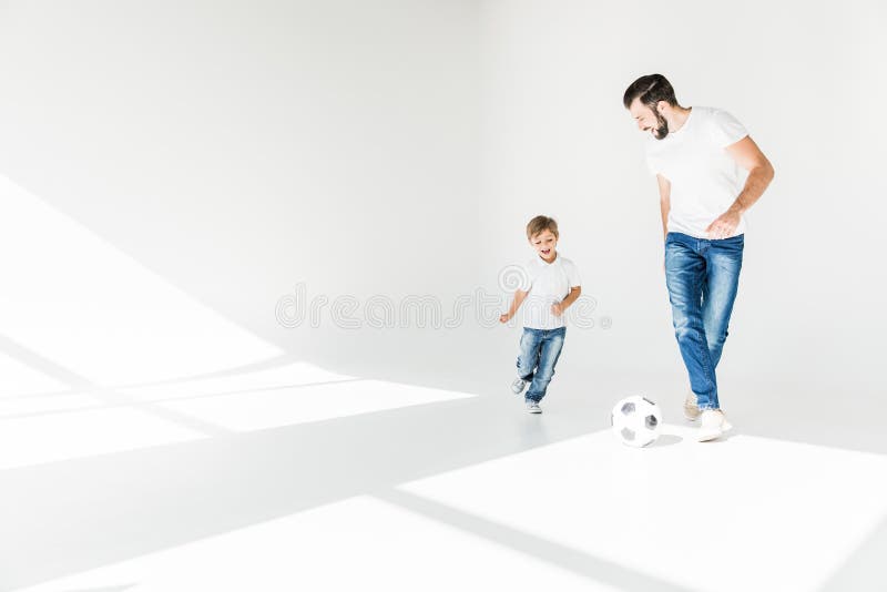 Fader och son med fotbollbollen fotografering för bildbyråer
