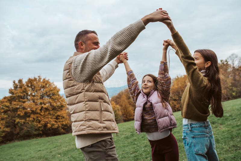 Fader som dansar med döttrar som håller händer. arkivbild