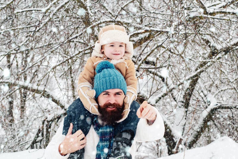 Fader som ger son skjuts tillbaka i parken Cute son kramar sin pappa på vintersemester Bästa vinterspel för lyckliga familjer arkivfoto