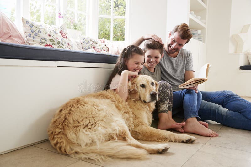 FaderReading Book With son och dotter och älsklings- hund hemma royaltyfri fotografi FaderReading Book With son och dotter och älsklings- hund hemma royaltyfri fotografi