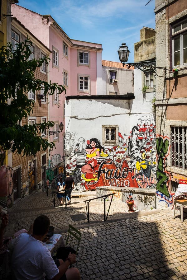 Fado Graffiti in Alley in Lisbon Portugal with a Gentleman Sitting in