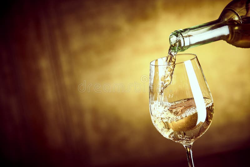 Fahne, die ein Glas Weißwein von einer Flasche ofPouring ist lizenzfreies stockfoto