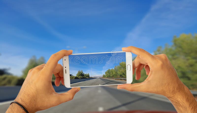 Fahren und Telefonkonzept Hände, die einen Smartphone, ein Foto auf Unschärfestraßenhintergrund machend halten Abbildung 3D vektor abbildung Fahren und Telefonkonzept Hände, die einen Smartphone, ein Foto auf Unschärfestraßenhintergrund machend halten Abbildung 3D vektor abbildung