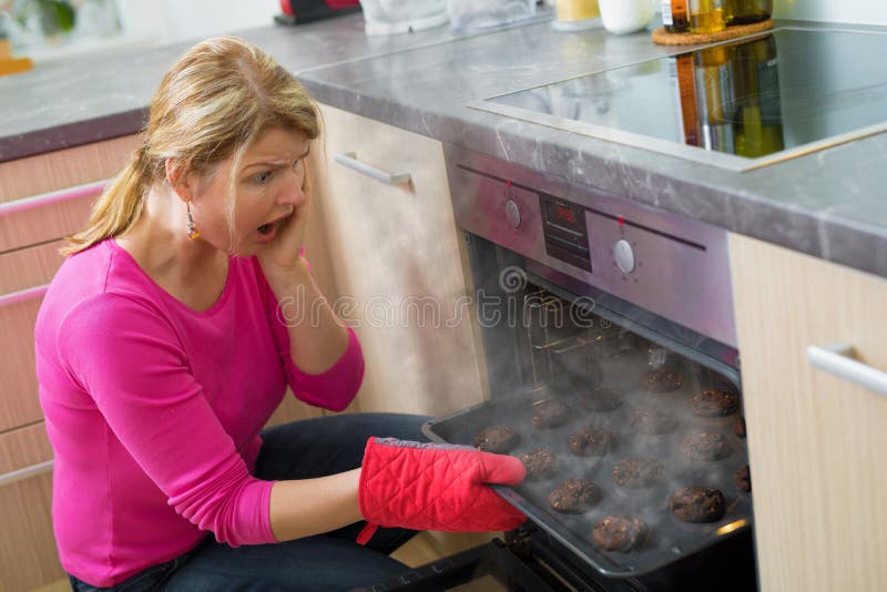 Middle aged woman failed cooking in kitchen. Middle aged woman failed cooking in kitchen