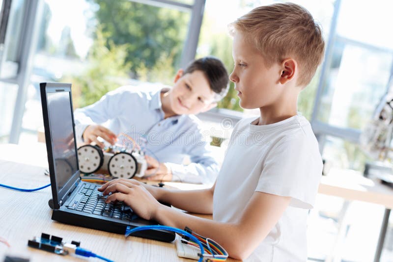 Fair-haired boy programming his new robot