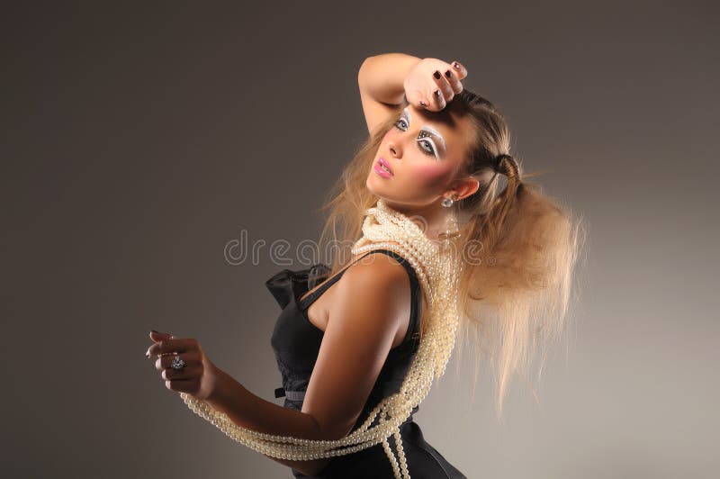 Fair-haired girl in black dress and pearl beads