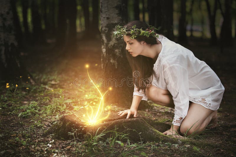 Bella ragazza fissando fate in un bosco magico.