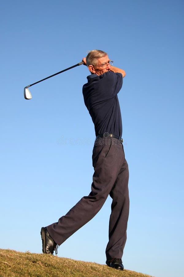 Senior golfer playing a stroke on the fairway. Senior golfer playing a stroke on the fairway