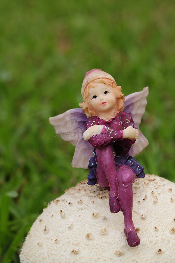 A fairy figurine on a mushroom in the garden