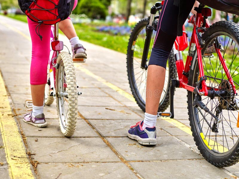 Fait du vélo la fille de cycliste Pieds d'enfants et roue de bicyclette basse section image stock Fait du vélo la fille de cycliste Pieds d'enfants et roue de bicyclette basse section image stock