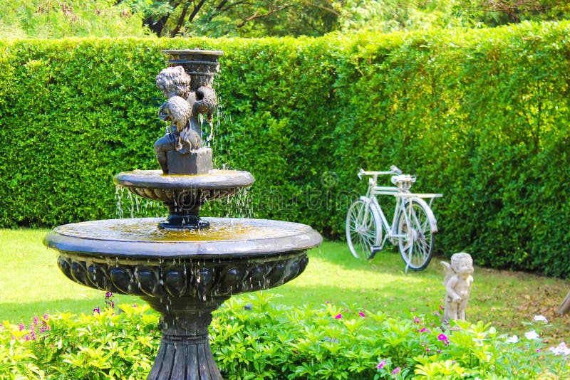 Faites du jardinage avec de petits arbres d'usines de pelouse de vert de banc de fontaine et de pierre photos libres de droits Faites du jardinage avec de petits arbres d'usines de pelouse de vert de banc de fontaine et de pierre photos libres de droits