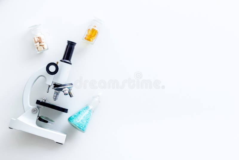 Faites la recherche médicale avec le microscope, pilules dans des essai-tubes dans le laboratoire sur la maquette blanche de vue image libre de droits Faites la recherche médicale avec le microscope, pilules dans des essai-tubes dans le laboratoire sur la maquette blanche de vue image libre de droits