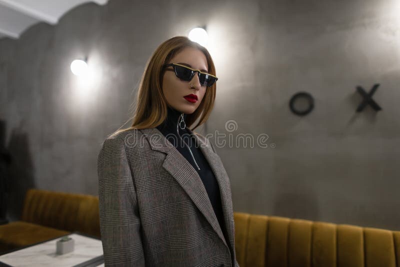 Fajna, stylowa młoda hipster kobieta w czarnych modnych okularach słonecznych w vintage stylowa, kieszonkowa kurtka z czerwonymi fotografia stock