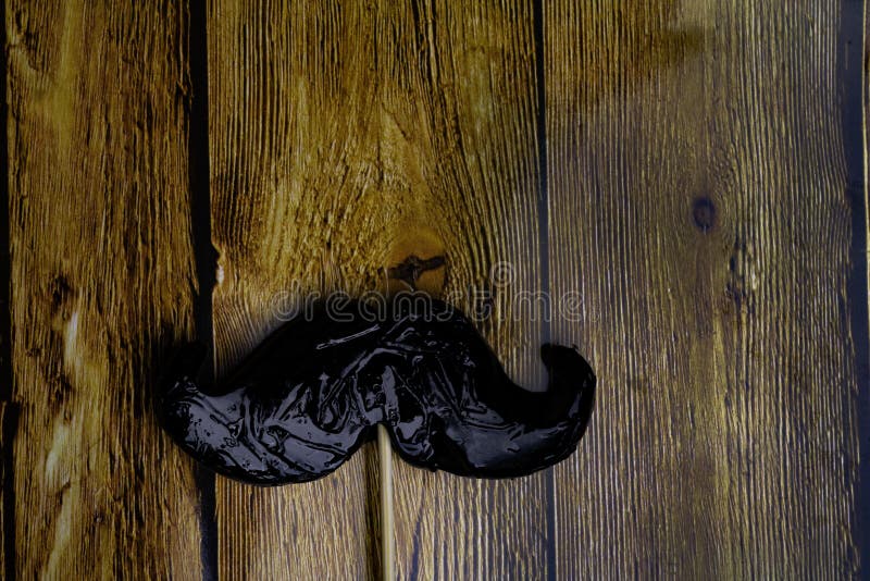 Fake moustache on a wooden background.. Photo props mustaches. men day, Birthday and Party Set and wedding. Flat lay, top view, co stock photos Fake moustache on a wooden background.. Photo props mustaches. men day, Birthday and Party Set and wedding. Flat lay, top view, co stock photos