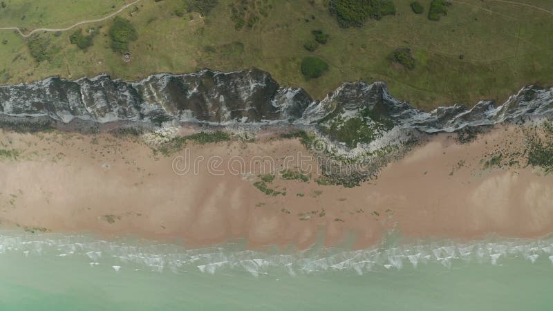 Falaise avec le sommet aérien aérien lent de la nature de l'océan rural turquoise et de pré vert en bas de la vue d'oiseaux banque de vidéos