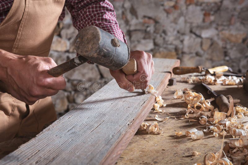 Falegname che per mezzo dello scalpello per lisciare giù legno fotografia stock libera da diritti Falegname che per mezzo dello scalpello per lisciare giù legno fotografia stock libera da diritti