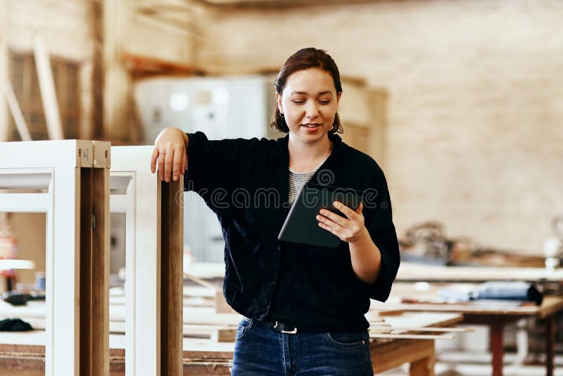 Falegname da laboratorio e donna con tablet per leggere ricerche e informazioni sulle punte di legno. piccola impresa immagini stock libere da diritti