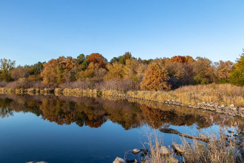 Fall colors in a park with reflections in the lake in Omaha Nebraska