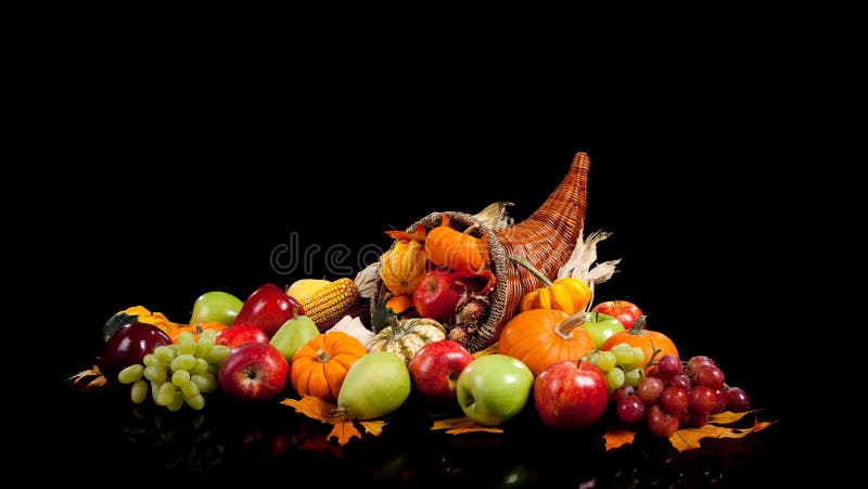 Caduta accordo di frutta e verdura in una cornucopia su sfondo nero (mele, uva, pere, zucche, zucche e foglie cadute.