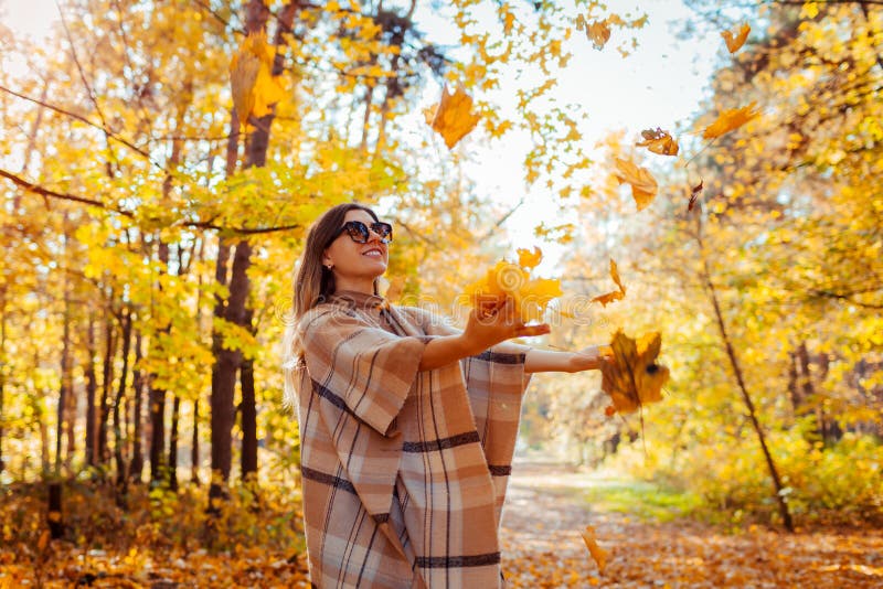 Fall season. Woman throwing leaves in autumn forest. Young woman having fun outdoors royalty free stock images Fall season. Woman throwing leaves in autumn forest. Young woman having fun outdoors royalty free stock images