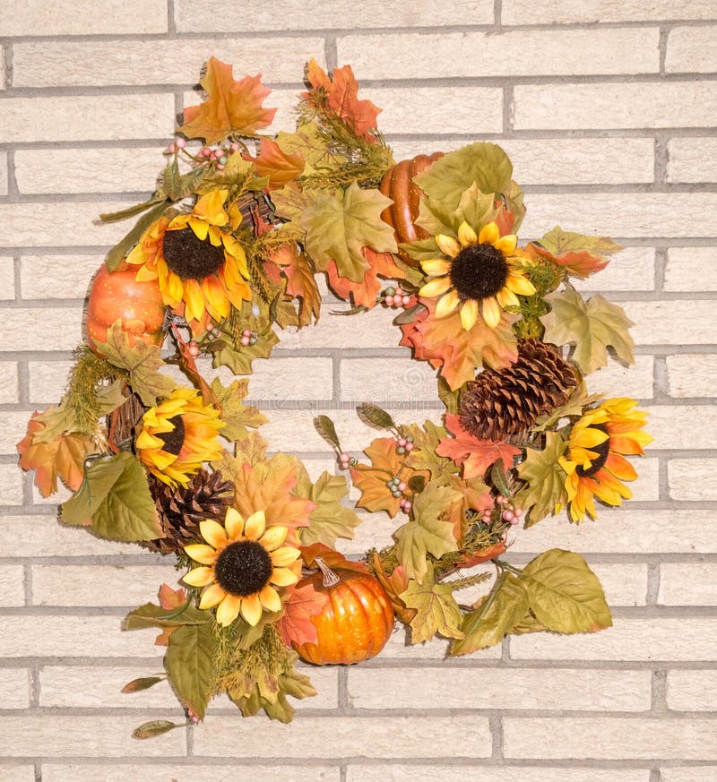 round Fall wreath on brick wall, pumpkins, pine cone, flowers upstate rural New York. round Fall wreath on brick wall, pumpkins, pine cone, flowers upstate rural New York