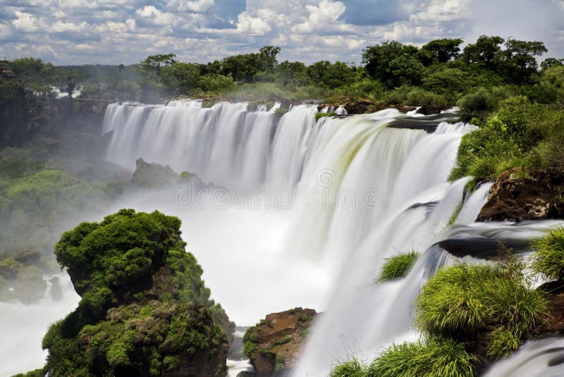 Iguassu Falls is the largest series of waterfalls on the planet, located in Brazil, Argentina, and Paraguay in South America. During the rainy season one can see as many as 275 separate waterfalls cascading along the edges of 2, 700 meters or 1. 6 miles cliffs. Argentines spells this wonder, Ã¬IguazuÃ®, the Brazilians, Ã¬Igaucu. Ã® Both versions are globally correct and widely used. South America. Iguassu Falls is the largest series of waterfalls on the planet, located in Brazil, Argentina, and Paraguay in South America. During the rainy season one can see as many as 275 separate waterfalls cascading along the edges of 2, 700 meters or 1. 6 miles cliffs. Argentines spells this wonder, Ã¬IguazuÃ®, the Brazilians, Ã¬Igaucu. Ã® Both versions are globally correct and widely used. South America