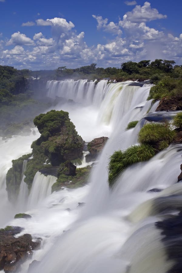 Iguassu Falls is the largest series of waterfalls on the planet, located in Brazil, Argentina, and Paraguay in South America. During the rainy season one can see as many as 275 separate waterfalls cascading along the edges of 2, 700 meters or 1. 6 miles cliffs. Argentines spells this wonder, Ã¬IguazuÃ®, the Brazilians, Ã¬Igaucu. Ã® Both versions are globally correct and widely used. South America. Iguassu Falls is the largest series of waterfalls on the planet, located in Brazil, Argentina, and Paraguay in South America. During the rainy season one can see as many as 275 separate waterfalls cascading along the edges of 2, 700 meters or 1. 6 miles cliffs. Argentines spells this wonder, Ã¬IguazuÃ®, the Brazilians, Ã¬Igaucu. Ã® Both versions are globally correct and widely used. South America