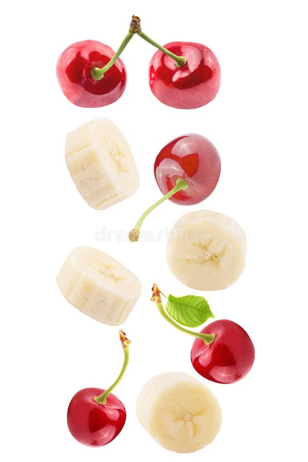 Falling sliced banana and cherries isolated on white