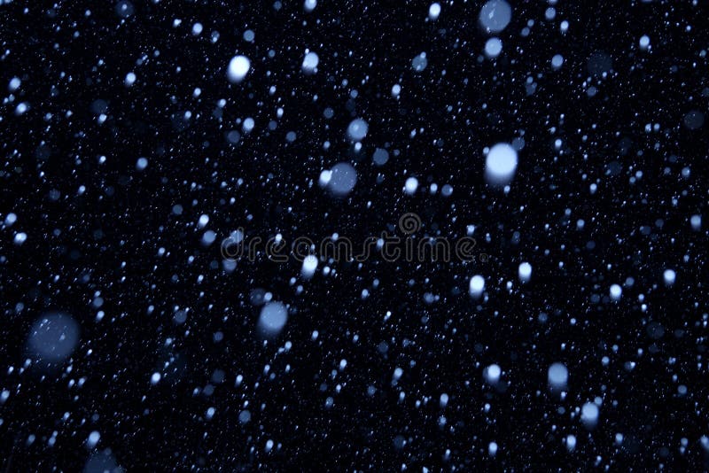 Falling snow on a dark background royalty free stock photography