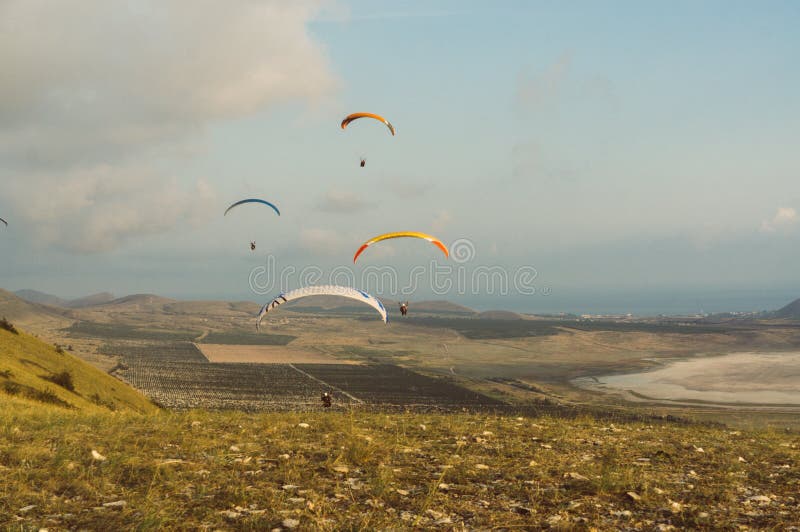 Fallschirmspringer, die im blauen Himmel über szenischer Landschaft von Krim gleiten, Ukraine, stockfotografie Fallschirmspringer, die im blauen Himmel über szenischer Landschaft von Krim gleiten, Ukraine, stockfotografie