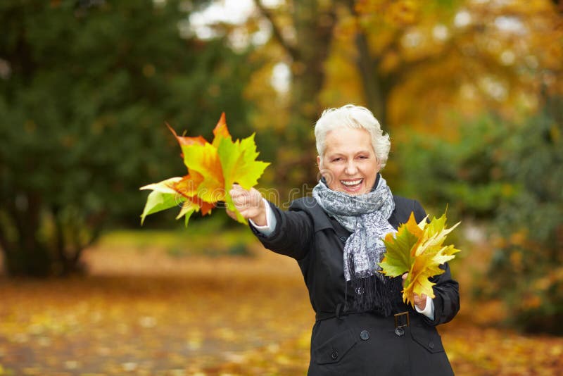 Senior citizen strolling in a park in autumn. Senior citizen strolling in a park in autumn