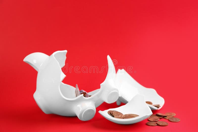 Broken piggy bank with money on red background. Broken piggy bank with money on red background