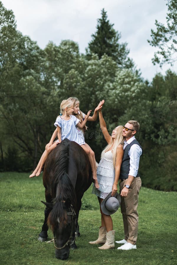 Foto Jovem feliz sorrindo família com cavalo. Família de quatro