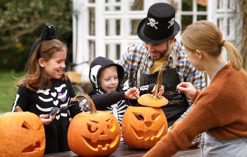 Família Jovem E Feliz, a Fantasia De Halloween Esculpindo Abóboras Juntas  No Quintal Foto de Stock - Imagem de paternidade, outono: 231540566