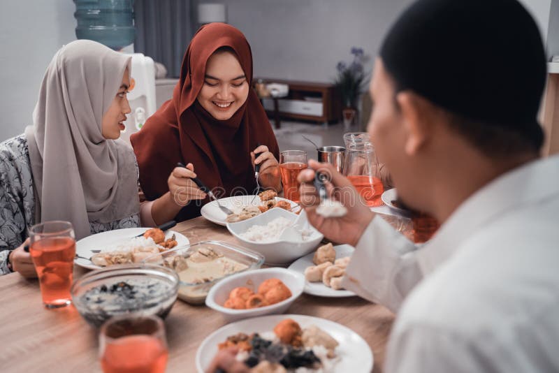 Fam?lia asi?tica mu?ulmana para apreciar junto a refei??o iftar na sala de jantar fotografia de stock royalty free Fam?lia asi?tica mu?ulmana para apreciar junto a refei??o iftar na sala de jantar fotografia de stock royalty free