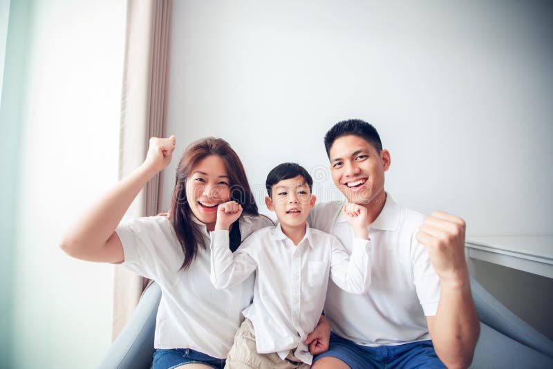 Fam?lia entusiasmado e feliz com os bra?os aumentados ao olhar a televis?o em casa fotografia de stock Fam?lia entusiasmado e feliz com os bra?os aumentados ao olhar a televis?o em casa fotografia de stock